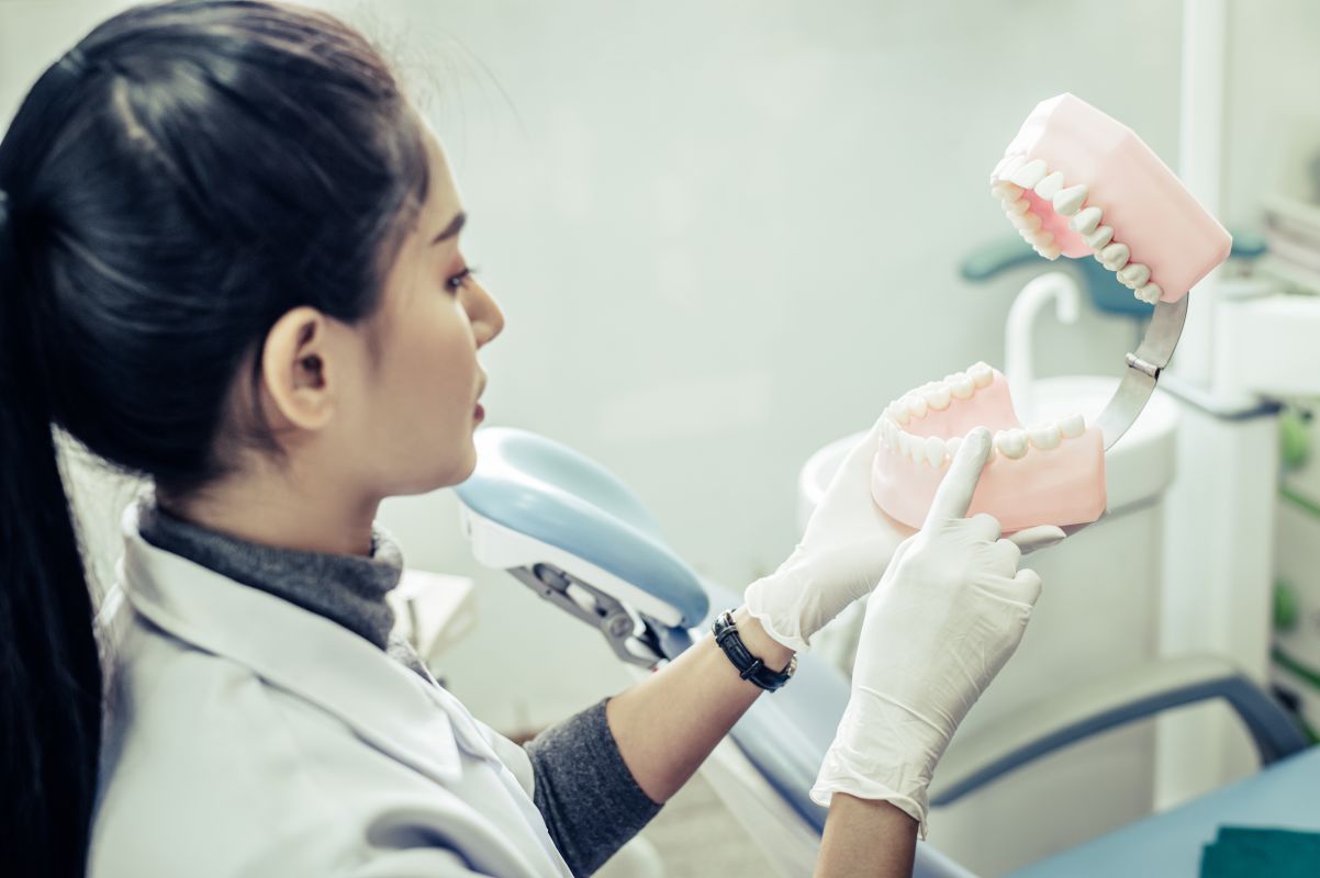 Female dentist explaining dental implants to patient in clinic